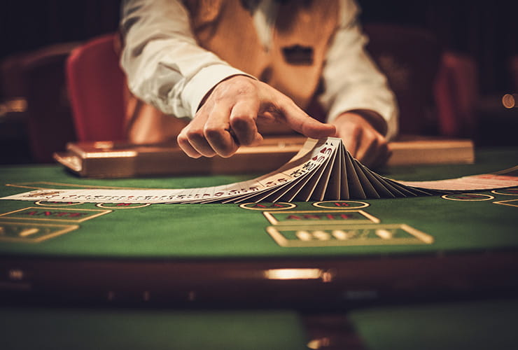 Blackjack dealer playing with cards