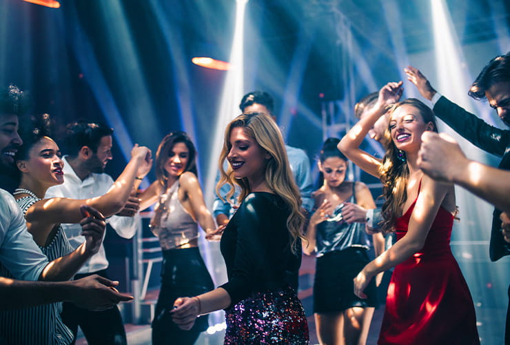 A group of people having a great time and dancing in the club