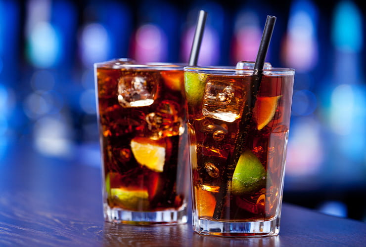 Two large glasses filled with soft drinks