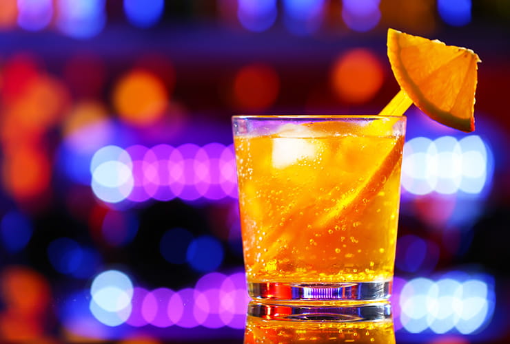 A glass of orange soft drink