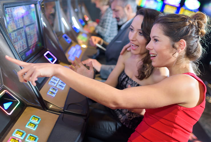 Two ladies playing at the slot machines