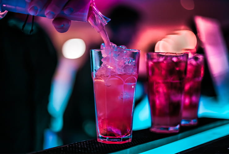 Three tall glasses filled with soft drinks and ice cubes