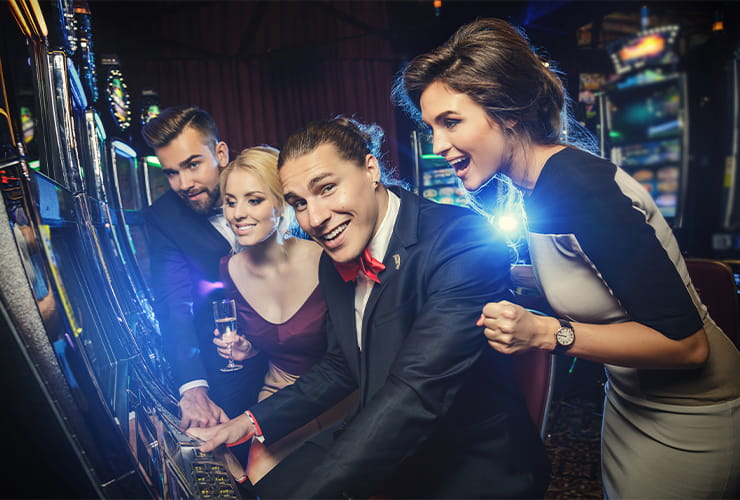 Two couples playing at the slot machines